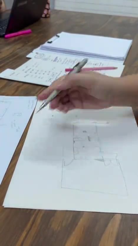 Iasmin desenhando a planta de um projeto à mão